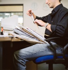 Man with Stack of Paperwork at the Office